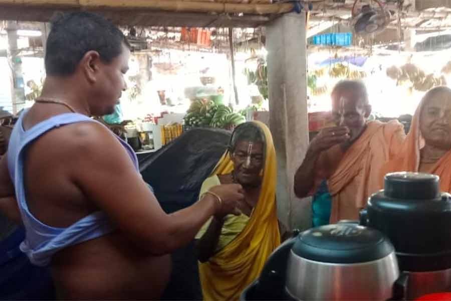 ভিক্ষুকদের হাতে চা, বিস্কুট দিচ্ছেন পূর্বস্থলীর তপন দেবনাথ।