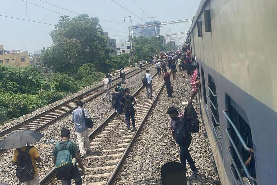 ট্রেন থেকে নেমে লাইন ধরে হাঁটছেন যাত্রীরা।