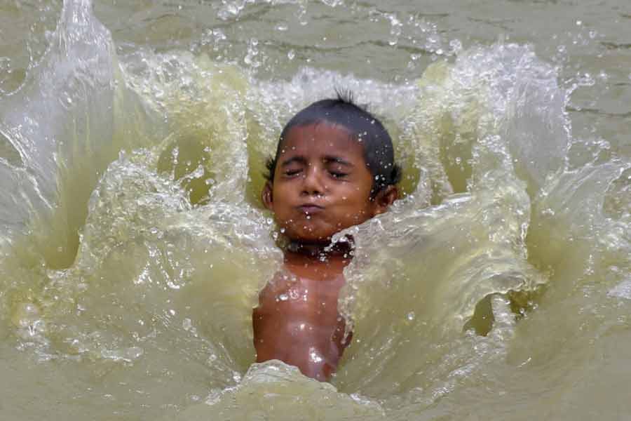 হাঁসফাঁস গরমে শরীর ভিজিয়ে নেওয়া। ছবি: পিটিআই।