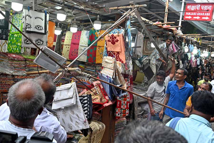 অভিযান: ফুটপাতে বসা হকারদের স্টলের অতিরিক্ত অংশ খুলে ফেলার কাজ চলছে। মঙ্গলবার, গড়িয়াহাট এলাকায়।