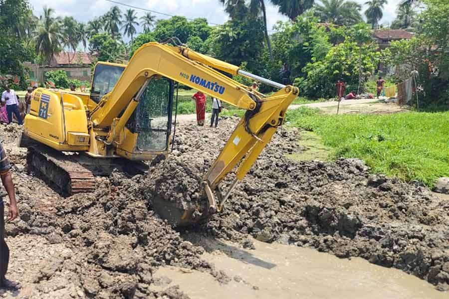 পুকুর থেকে মাটি তোলা হচ্ছে।