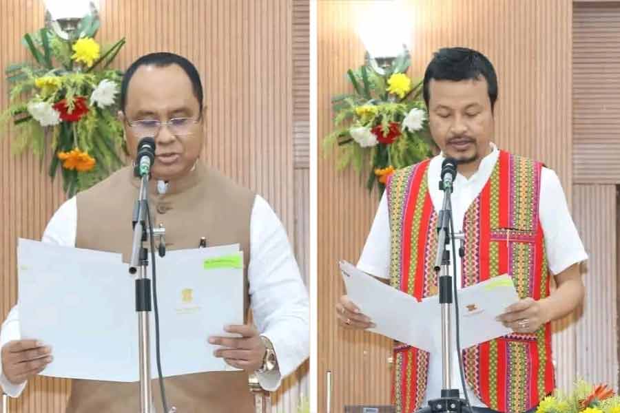 মন্ত্রী হিসাবে শপথ নিচ্ছেন সদ্য প্রাক্তন বিরোধী দলনেতা অনিমেষ দেববর্মণ (বাঁ দিকে) এবং তিপ্রা মথার আর এক বিধায়ক বৃষকেতু দেববর্মণ।