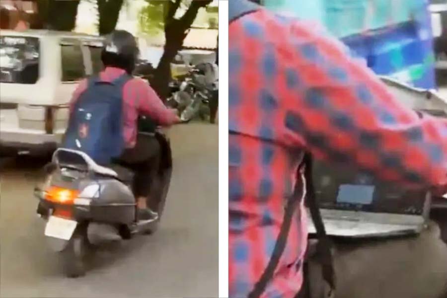 Man attends Zoom call from laptop while riding on a scooter
