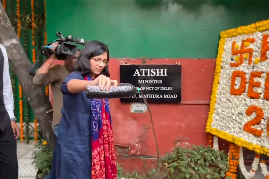 দিল্লির মুখ্যমন্ত্রীর বাসভবনের সামনে নোংরা জল ঢালছেন আপ সাংসদ স্বাতী মালিওয়াল।