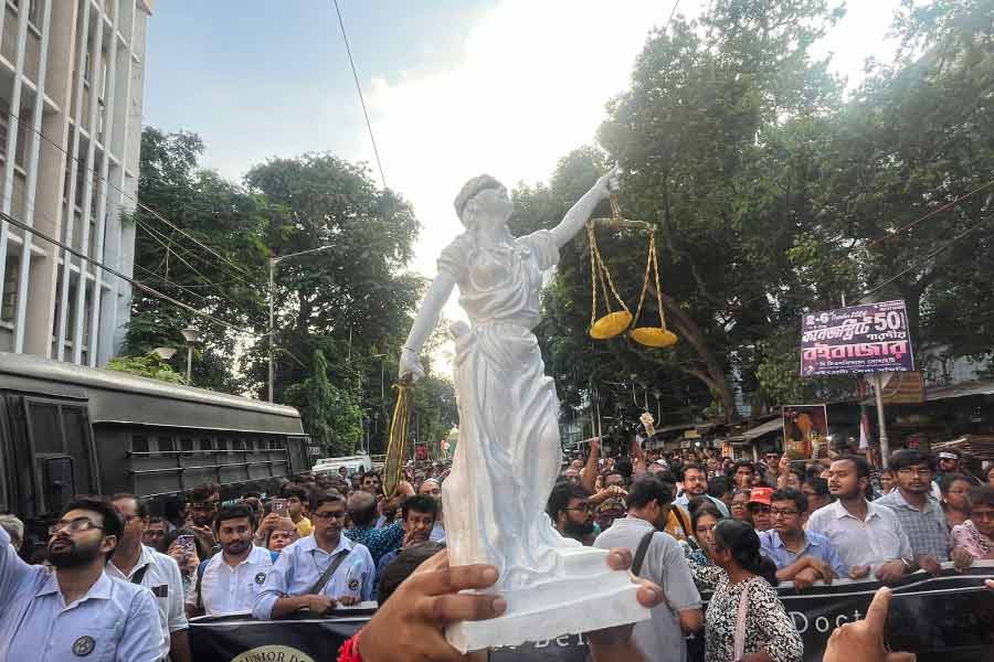 আন্দোলনকারীদের হাতে ন্যায়ের মূর্তি। 
