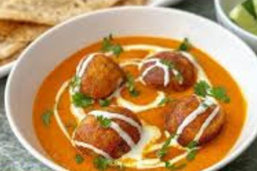 এ বার হলুদ, জিরে গুঁড়ো, লাল লঙ্কা, ধনে গুঁড়ো, নুন এবং চিনি দিন। ভাল করে কষানো হয়ে গেলে এর মধ্যে কাজু এবং পোস্ত বাটা দিতে হবে।  এবার কোফতাগুলো দিয়ে পরিমান মতো জল দিন। ফুটে উঠলে ফ্রেশ ক্রিম ছড়িয়ে দিলেই তৈরি জিভে জল আনা কাঁচকলার মালাই কোফতা। 