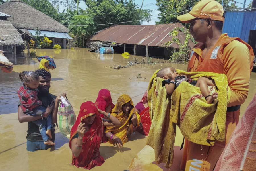 বন্যাকবলিত এলাকা থেকে বাসিন্দাদের উদ্ধারের কাজ চলছে। ছবি: পিটিআই।