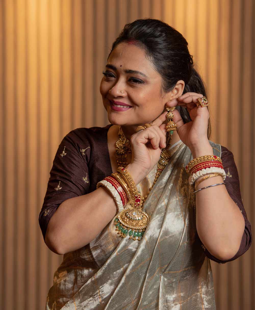 শাড়ি-পাঞ্জাবি, প্রেম, সাজগোজ— এগুলি ছাড়া পুজো সম্পূর্ণ নয়। রাতুল এবং রূপাঞ্জনাও সেটা বিশ্বাস করেন। তাই বিয়ের পরে প্রথম পুজোয় শুধু প্রেম নয়, সাজগোজেও চমক রাখার চেষ্টা করেছেন দু’জনে। এই যেমন রূপাঞ্জনার শাড়ি পরার ধরন কিন্তু বেশ চমকপ্রদ। সহজ অথচ সহজ নয়। একটু অন্য রকম। শাড়িতে কুঁচি আছে। কিন্তু কোমর ছাপানো আঁচল নেই।