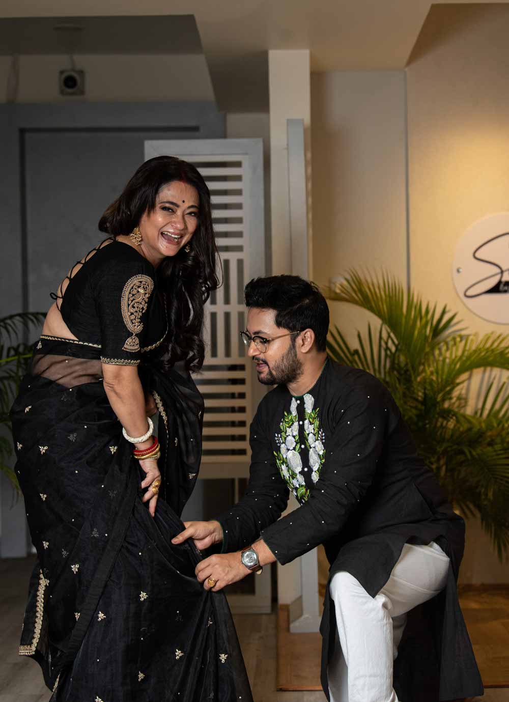 রূপাঞ্জনার সাজে রাতুলের মন হারাল বটে, তবে সপ্তমীতে স্ত্রীর শাড়ির কুঁচি ধরে দিতে ভুললেন না তিনি। সপ্তমীতে রূপাঞ্জনা ‘ব্ল্যাক লেডি’। লিনেন সুতোর কাজ করা কালো অরগ্যাঞ্জায় নিজেকে সাজালেন তিনি। আর রাতুল তো ঠিক করেই নিয়েছেন, পুজোয় পাঞ্জাবি ছাড়া কিছু পরবেন না। রঙিন সুতোর ঠাসা কাজ করা পাঞ্জাবিতে যোগ্য সঙ্গত দিয়েছেন রাতুল।