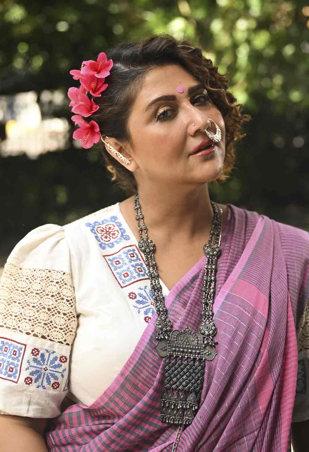 আশ্বিন মাসে পুজো হলেও কলকাতায় যেন অধিকাংশ সময় গরম। সেই কথা মাথায় রেখেই স্বস্তিকার পরবর্তী শাড়ি গোলাপি ধূসর রঙের মিশ্রণে তৈরি এই হ্যান্ডলুম শাড়ি। সঙ্গে ক্রুশুরে কাজ করা সাদা ব্লাউজ়। নাকে রুপোর নথ, ইয়ার কাফে অবশ্য ষোলো আনা বাঙালিয়ানা। সুকুমার রায়ের আবোল তাবোল। এই সাজের সঙ্গেও চুলে রঙিন ফুল, কপালে গোলাপি টিপ।