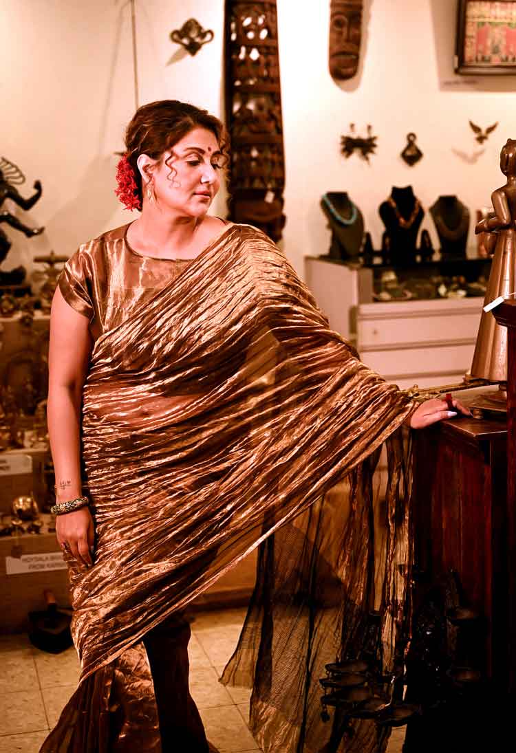 নবমীর রাতের জন্য স্বস্তিকা বেছে নিয়েছিলেন সোনালি টিস্যুর শাড়ি। নাম দিলেন গয়না শাড়ি। যদিও এই শাড়ির সঙ্গে খুব বেশি কিছু গয়না পরেননি অভিনেত্রী। কপালে লাল গুঁড়ো টিপ, চুলে লাল ফুল ও আঙুলে লাল আংটি। স্বস্তিকার কথায়, ‘‘আসলে এই শাড়িটা এতটা ঝলমলে, গয়না শাড়ি বলা ভাল। এই ধরনের হালকা অথচ জমকালো শাড়ি নবমীর রাতের জন্য ভাবা যেতেই পারে। এর সঙ্গে গুঁড়ো টিপ পরেছি, সেটা আমার মায়ের থেকে পাওয়া। বেনারস গেলেই মা কিনে আনতেন, এখন কলকাতাতেই পাওয়া যায়।’’ 