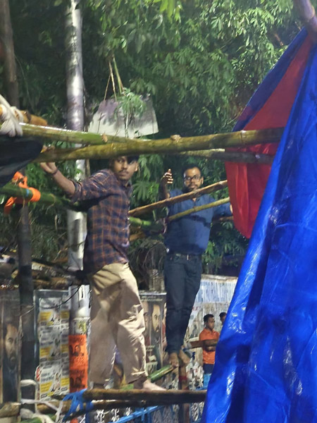 বৃষ্টিতে ভিজেই মঞ্চ বাঁধছেন ডাক্তারেরা।