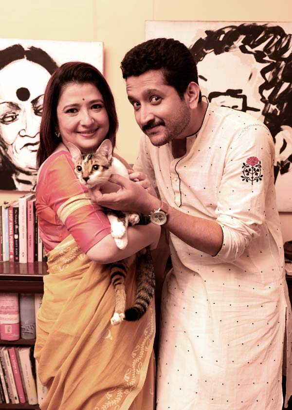 হলুদ সুতির শাড়ির উপরে লক্ষ্মীর পা আর ধানের শিষের আঁকিবুকি। সঙ্গী কমলা রঙের ব্লাউজ়। গলায় হালকা কাদম্বিনী মুক্তোর হার। পরমব্রতের পরনে সাদার উপর এমব্রয়ডারি করা ধুতি ও পাঞ্জাবি। যোধপুর পার্কের সাজানো সংসারে রয়েছে আরও দুই গুরুত্বপূর্ণ সদস্য— সারমেয় কন্যা নিনা ও মার্জার পুত্র বাঘা। ক্যামেরার সামনে তুলনায় সাবলীল বাঘা। তাই সটান পরম-পিয়ার কোলে উঠে তাক করা ক্যামেরার দিকে ‘পারফেক্ট পোজ়’ দিয়ে ফেলতে বিন্দুমাত্র সমস্যা হয়নি তার। পিয়া বরাবরই মার্জারপ্রেমী। তবে সংসার পাতার পরে নিনার সঙ্গেও সখ্য হয়েছে তাঁর। পরম আবার দু’জনের সঙ্গেই সমান ভাবে সময় কাটাতে পছন্দ করেন।