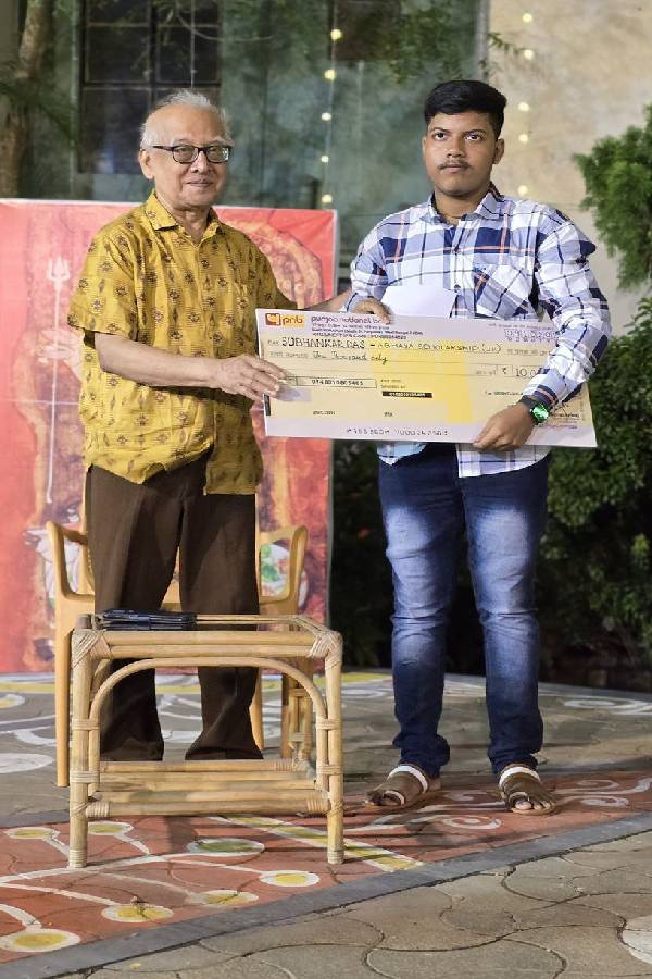 শুভঙ্কর দাসের হাতে স্কলারশিপের চেক তুলে দিচ্ছেন পবিত্র সরকার।