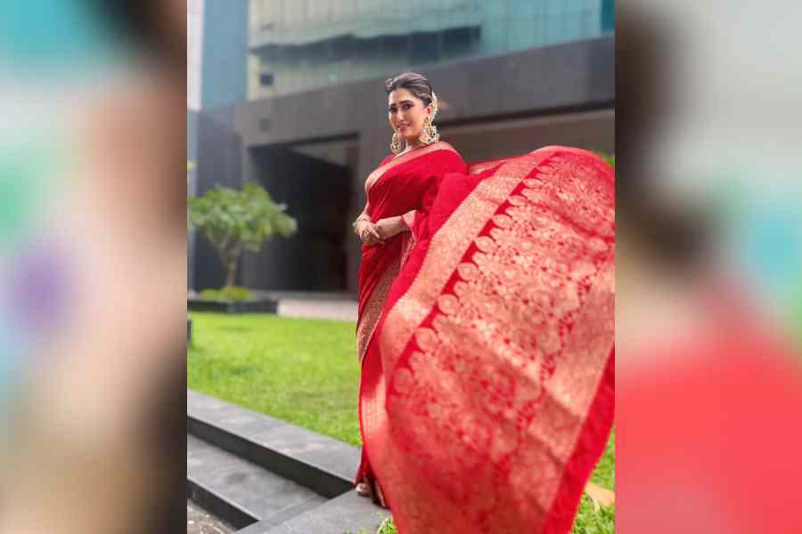 খোঁপায় জড়ানো ফুলের মালা। হাওয়ায় উড়ছে শাড়ির আঁচল। চওড়া পাড়ের লাল বেনারসিতে সপ্তমীর সাজে 'সম্পূর্ণ' সম্পূর্ণা লাহিড়ি।