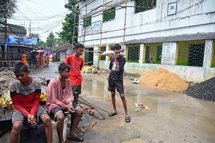 খানাবেড়িয়ায় স্কুলের সামনেই বসে স্কুলছুট কিশোরেরা। ছবি: দেশকল্যাণ চৌধুরী