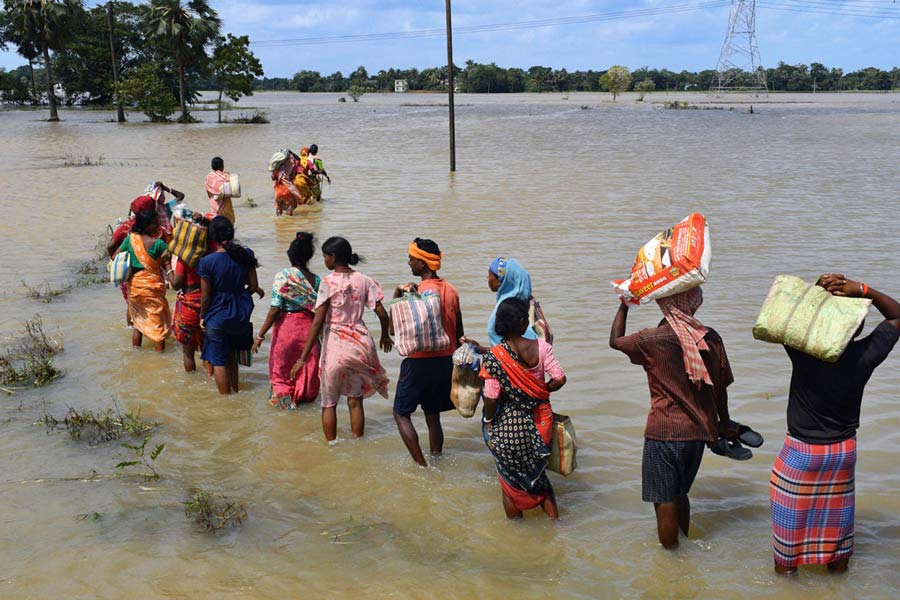 বিপন্ন: ত্রাণ সংগ্রহ করে ফিরছেন বন্যাদুর্গত মানুষ,পাঁশকুড়া।