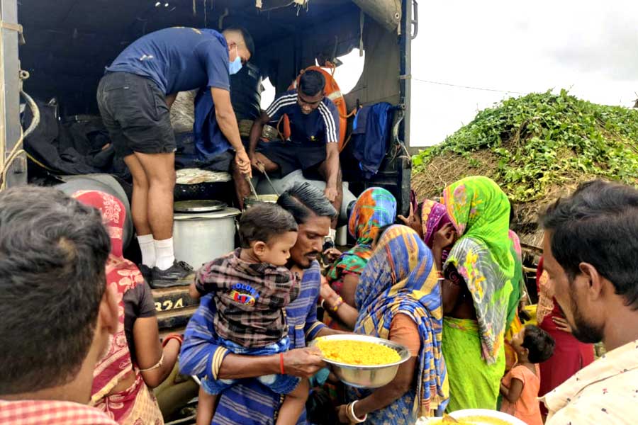 শনিবার ওড়িশার কেন্দ্রপাড়া জেলায় বিপর্যয় কবলিত এক গ্রামে খাবার বিলি করছে ভারতীয় নৌসেনা।