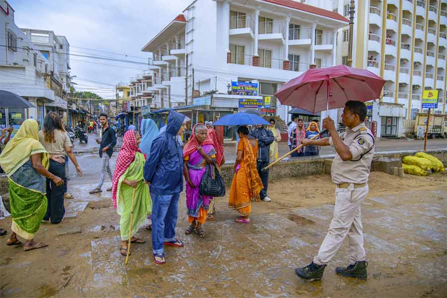 Puri: A police personnel asks visitors to vacate the beach in view of cyclone 'Dana' which is expected to make landfall in Odisha, in Puri, Thursday, Oct 24, 2024. (PTI Photo)(PTI10_24_2024_000314A)