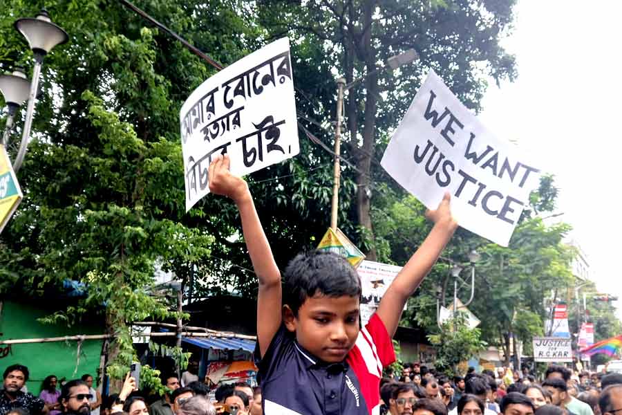 ‘উই ওয়ান্ট জাস্টিস’ লেখা পোস্টার হাতে নিয়ে এক শিশু। রবিবার দুপুরে কলেজ স্কোয়্যারে।