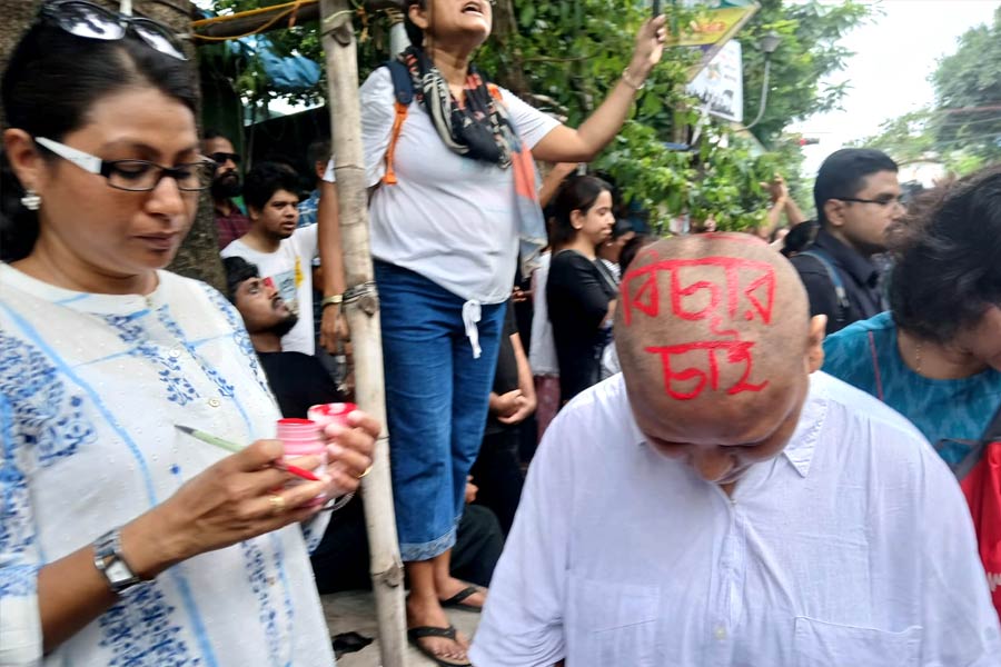 লাল রঙে তুলি ডুবিয়ে লেখা হয়েছে, ‘বিচার চাই’।