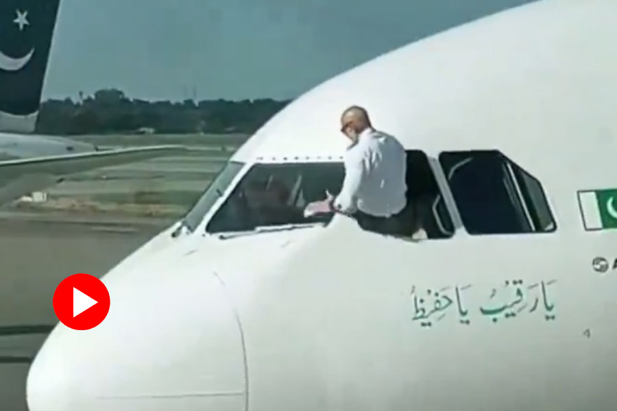 Pakistani pilot cleans windscreen from airplane before takeoff