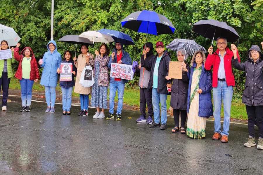 বার্মিংহ্যামে ছাতা মাথায় দিয়ে প্রতিবাদে প্রবাসীরা।