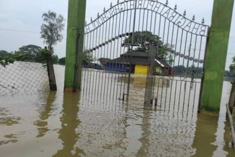 বন্যার জলে ভেসে গেছে স্কুলের গেট।