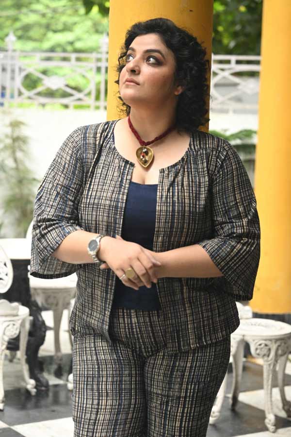 আভেরী সিংহরায়, তাঁর ডাগর দুই চোখে জ্বলে স্বপ্নের প্রদীপ। মিতবাক এই অভিনেত্রীর স্মিতহাস্যে ঝরে পড়ে আত্মবিশ্বাস। তাঁর পরিধানে সুতির থ্রি-পিস। এখানেও নীলের ছোঁয়া। তবে তার ছোট ছোট খোপে যেন ফুটে উঠেছে নাগরিক ব্যস্ততা। অভিনয় শিল্পে পুরুষের সঙ্গে কাঁধে কাঁধ মিলিয়ে কাজ করার দৃঢ়তা রয়েছে আভেরীর মধ্যে। সেই ছায়াই পড়েছে তাঁর পোশাকে। সামান্য আভরণে আভেরী গলায় পরেছেন একটি পিতলের প্রদীপ। সমকালের প্রতীক।