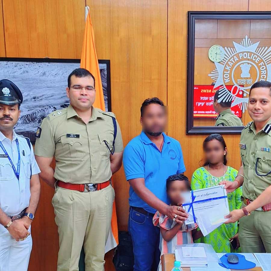বধূর হাতে পুরস্কার তুলে দিচ্ছে পুলিশ।