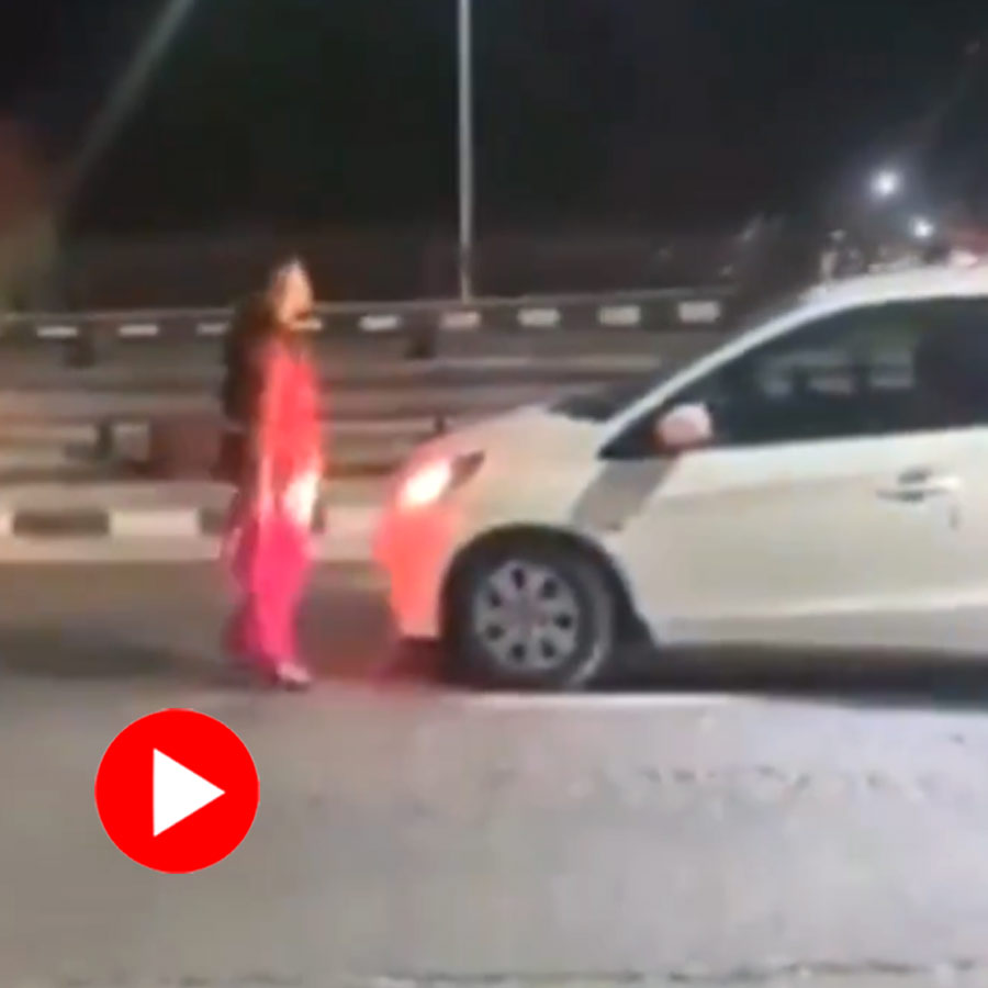 woman disrupting traffic and creating a scene on a busy road