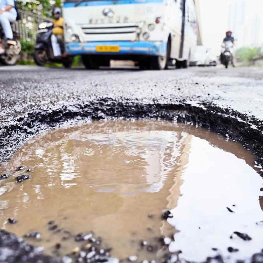 হাঁ করে থাকা এমন গর্তই বাড়াচ্ছে বিপদ। মঙ্গলবার, ই এম বাইপাসের পাটুলিতে।