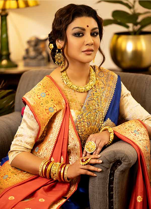 জয়া আহসানের একই অঙ্গে সে দিন কমলা আর নীল ফুটে ছিল! এক অঙ্গে দু’রকমের শাড়ি। দুটোই বেনারসি। একটি ঘন নীল। অন্যটা কমলা। দুই শাড়ির জমিনে সোনালি জরির ফুল।