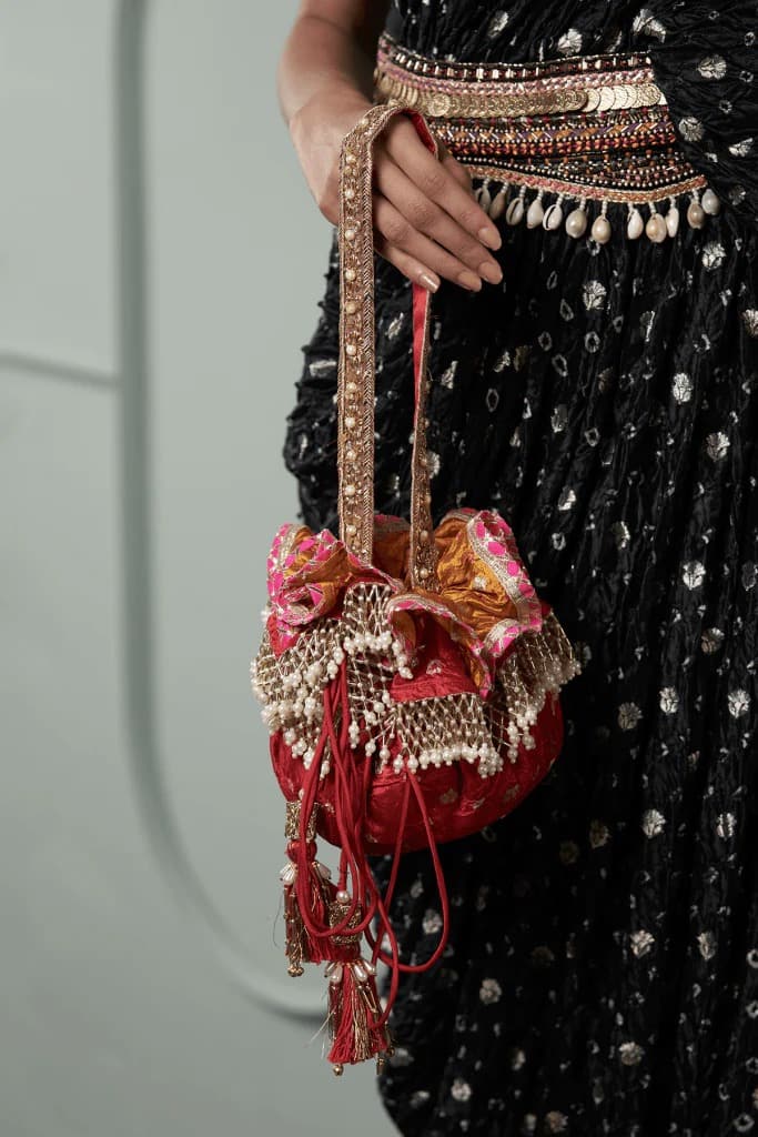 বটুয়া: ‘বিডস’ ব্যাগের প্রসঙ্গ যখন উঠলই, এদের নিয়েও কথা হোক। বাঙালি বিয়ে বাড়ির অনুষ্ঠানে সকলের দিকে একটু চোখ বোলালেই দেখতে পেয়ে যাবেন এই ব্যাগের রমরমা রাজপাট। জমকালো শাড়ি এবং ভারী সাজের সঙ্গে বটুয়া খুবই মানানসই। বিভিন্ন আকারের পুঁতি, কাচ বসানো এই পোটলি ব্যাগগুলি দেখতেও বেশ নজরকাড়া। 