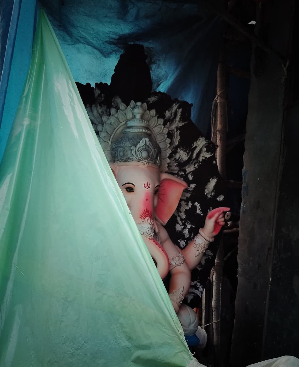 মণ্ডপে বিরাজ করার আগে মৃৎশিল্পীর আঙিনা থেকেই উঁকি একটি মিষ্টি গণেশের। 