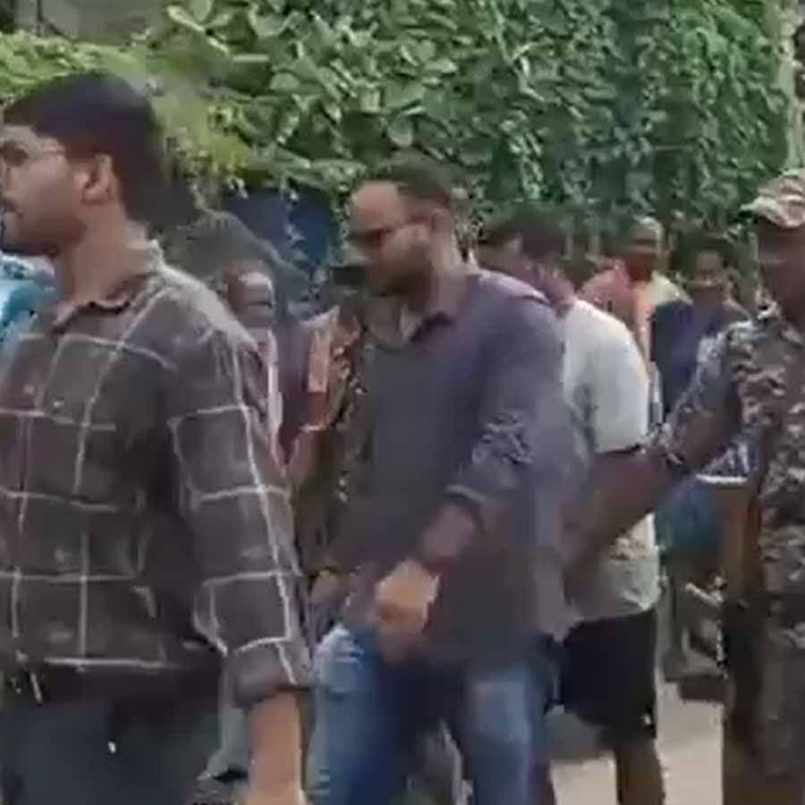 পালানোর চেষ্টার পর জীবনকৃষ্ণ সাহাকে ধরে বাড়িতে আনছেন ইডি আধিকারিকেরা। সোমবার সকালে।