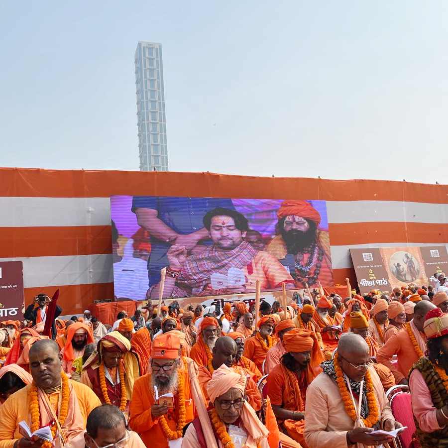 মঞ্চে গীতাপাঠ করছেন সাধুসন্তরা। পিছনের এলইডি স্ক্রিনে গীতাপাঠ করতে দেখা যাচ্ছে বাগেশ্বর ধামের প্রধান ধীরেন্দ্রকৃষ্ণ শাস্ত্রীকে। 