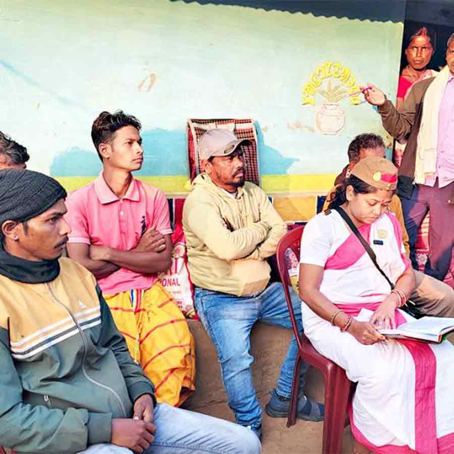 মুচিকাটা গ্রামের ডুংরিডি পাড়ায় মাঝি সরকার নিয়ে বাসিন্দাদের বোঝাচ্ছেন গীতা মুর্মু। বুধবার।