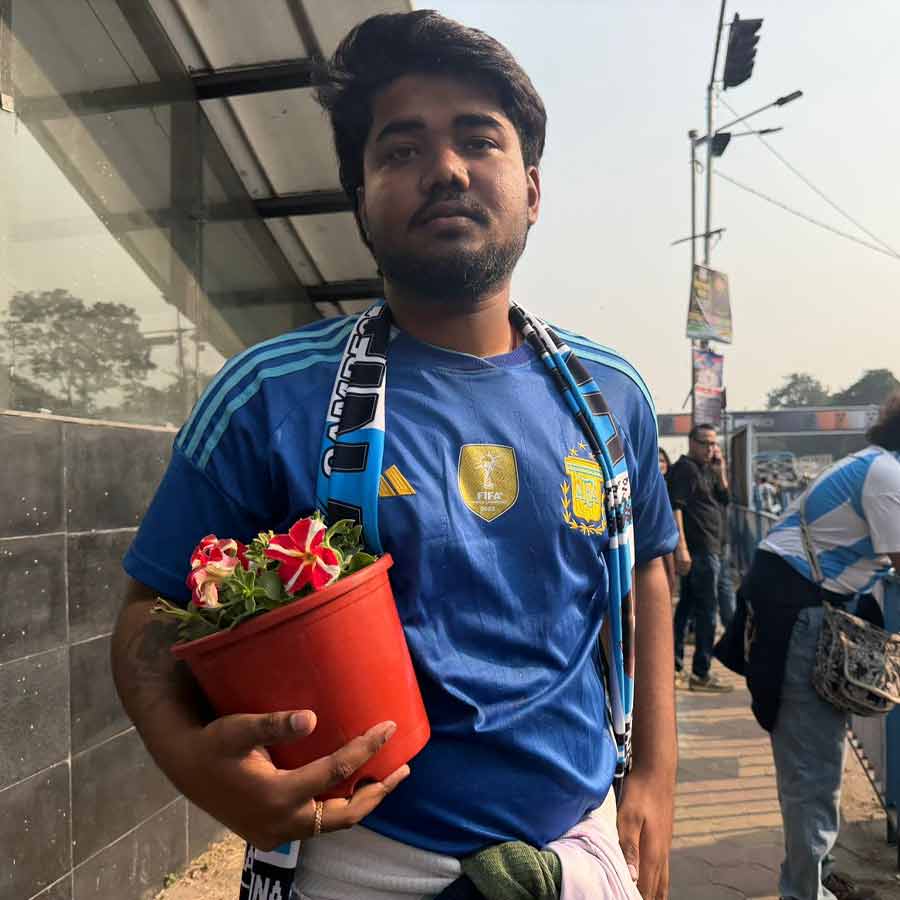 যুবভারতী থেকে ফুলের টব নিয়ে যাচ্ছেন এক দর্শক। 