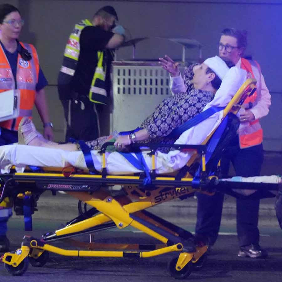 বন্ডাই সৈকতে গোলাগুলির পরে এক আহতকে উদ্ধার করে নিয়ে যাওয়া হচ্ছে।