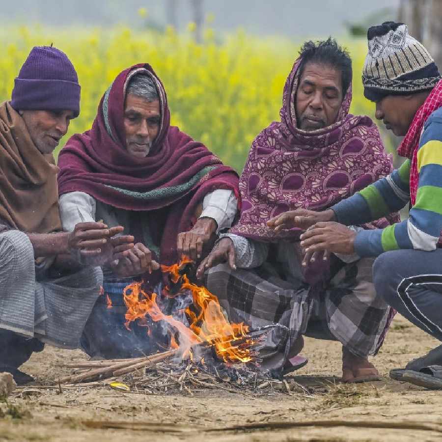 ঠান্ডার হাত থেকে বাঁচতে আগুন পোহাচ্ছেন গ্রামবাসীরা। নদিয়ায়।