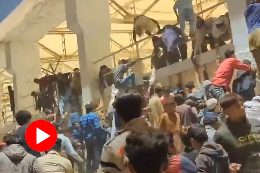 Pakistani people climb wall to enter Karachi Stadium during unveiling ceremony