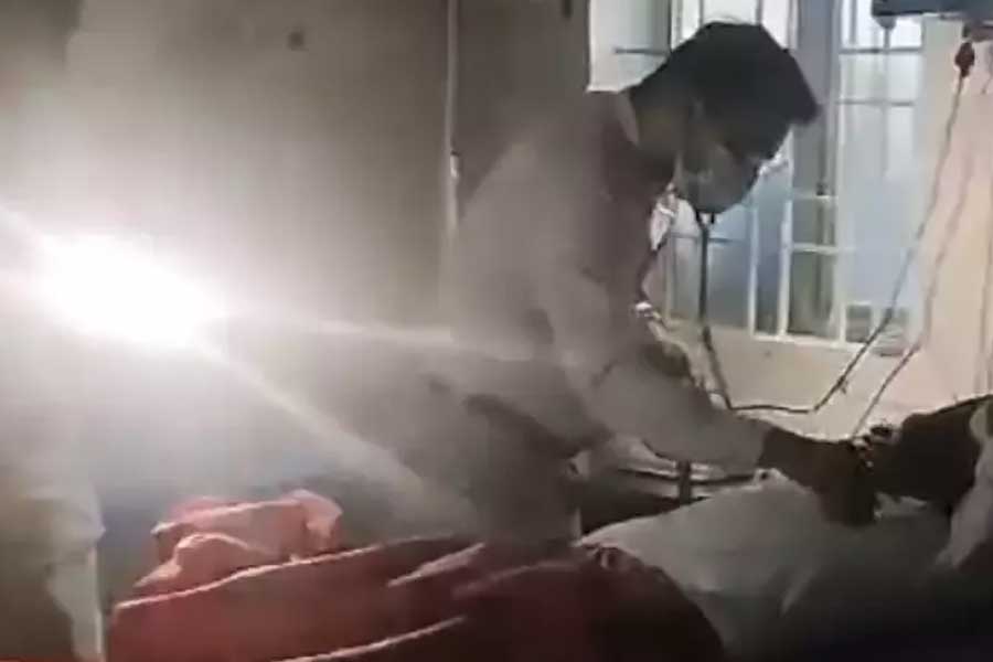 Injured man given stitches under the light from mobile phone flashlights in a Karnataka government hospital dgtl