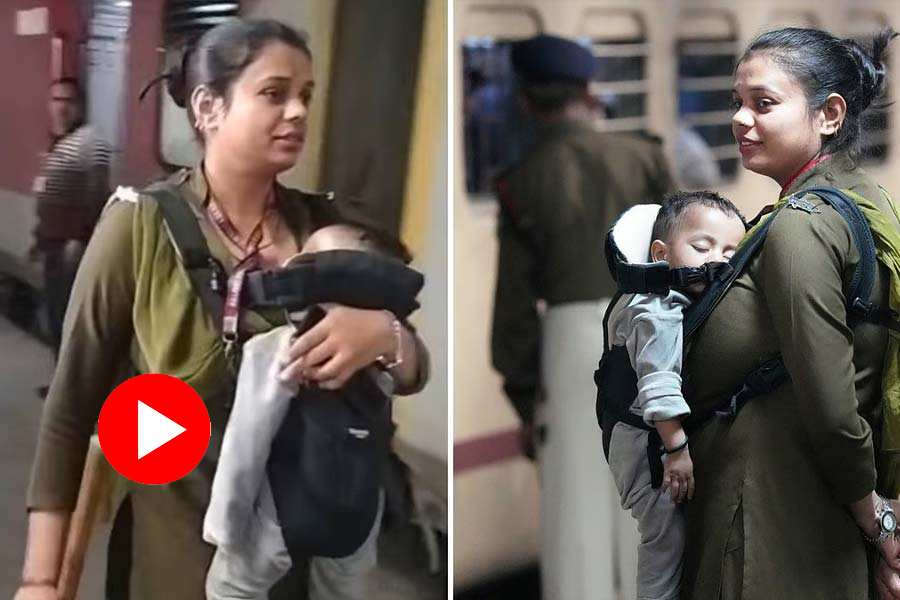 RPF officer maintaining order with her child