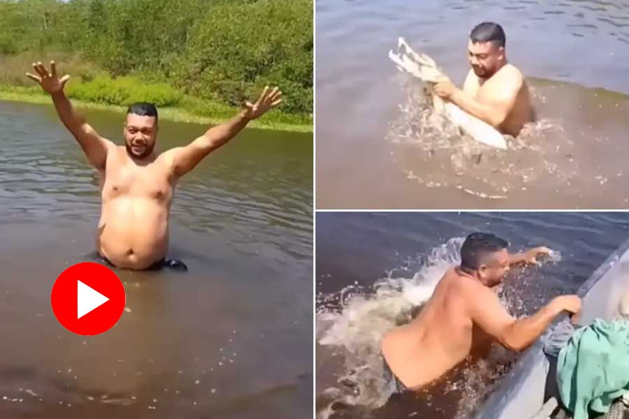 a man grabs crocodile in the middle of the river