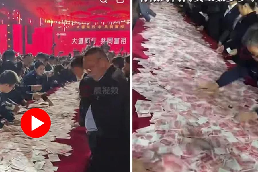 A video shows employees of a Chinese company stacking and counting cash kept on a table