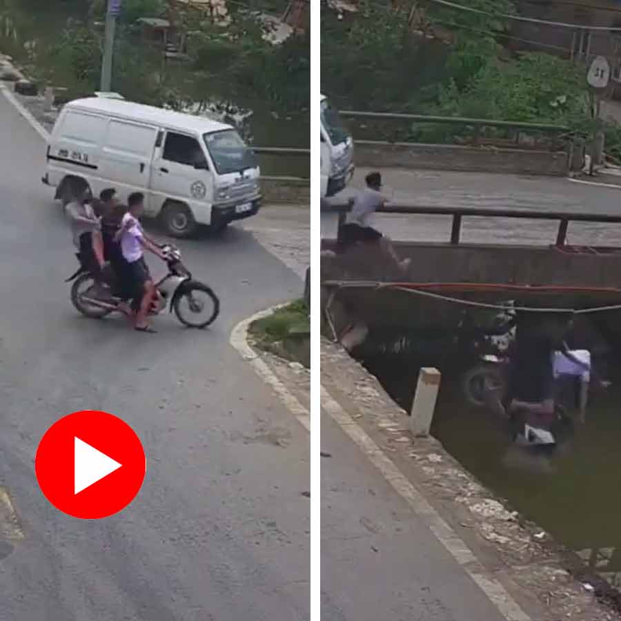Video of bike rider holding onto railing while the bike falling into roadside drain dgtl