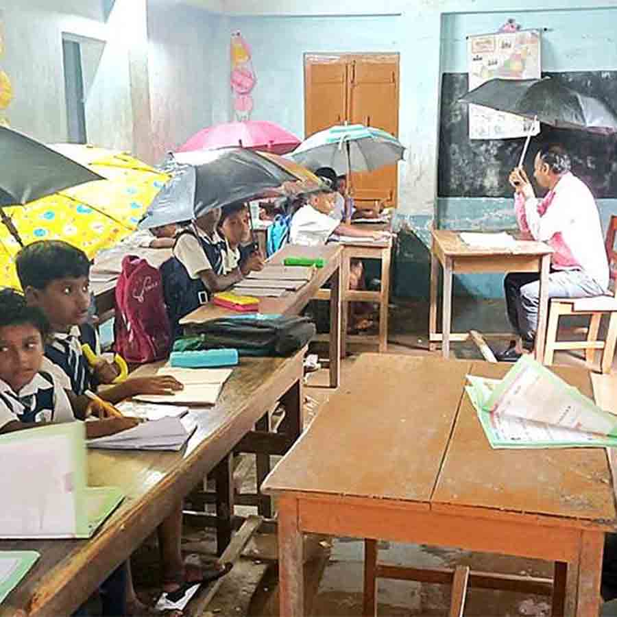 Students attending classes with umbrella due to leaked roof of classrooms