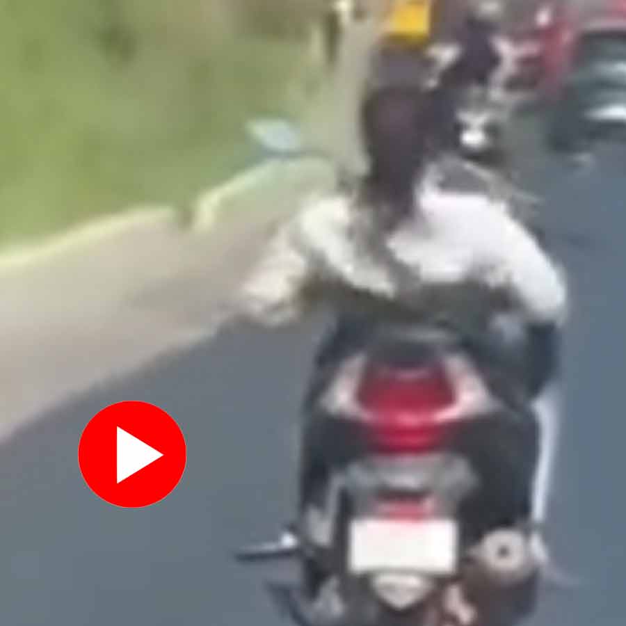 Video of woman without helmet stretching while riding scooter in middle of the road dgtl