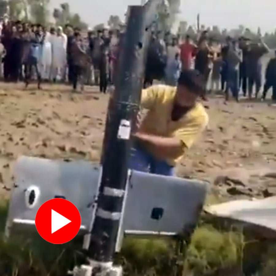 Pakistanis are seen smashing their own drone